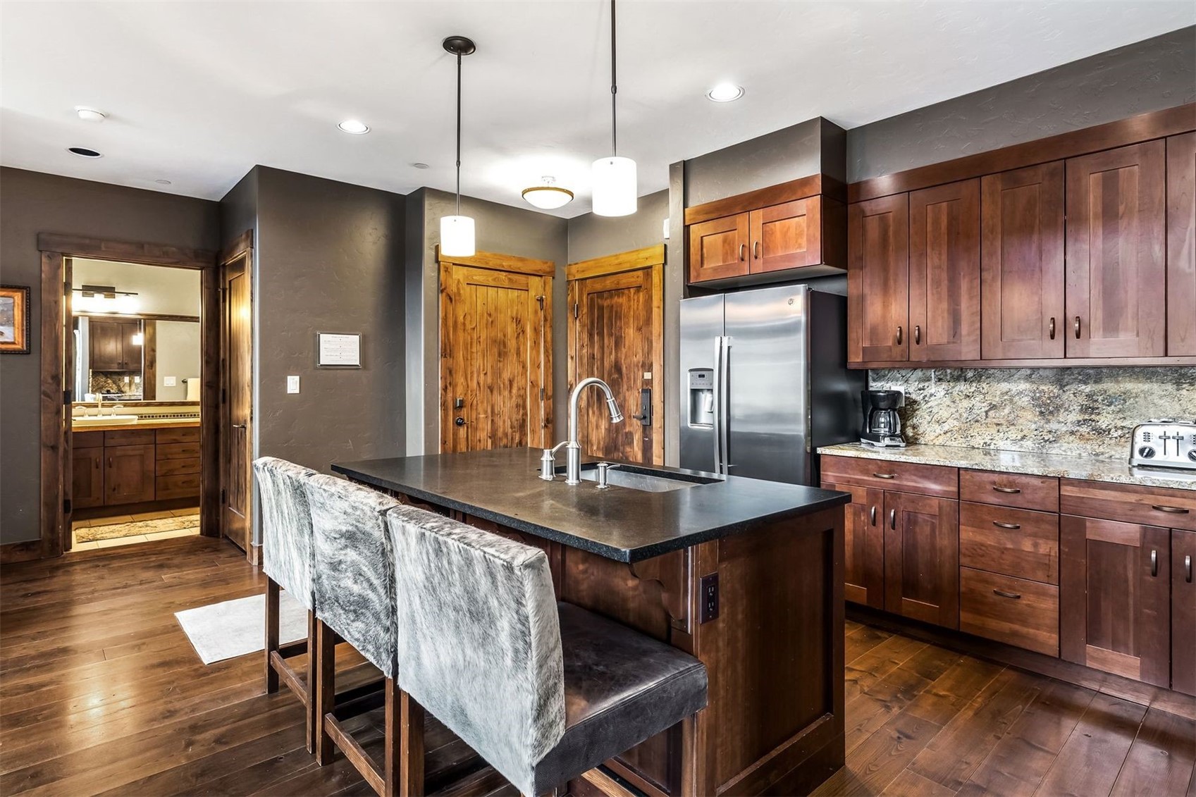 600 Columbine Road, Unit 5305 Breckenridge, CO 80424 - Photo 7 of 36 a kitchen with granite countertop a table chairs refrigerator and cabinets