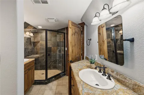 a bathroom with a granite countertop sink and a mirror