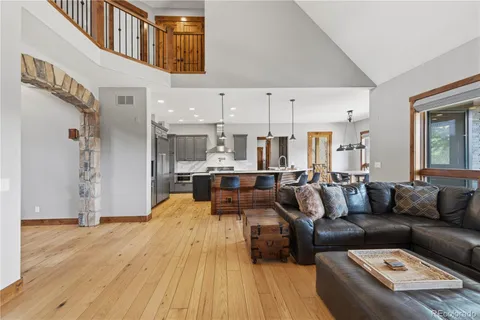 a kitchen with stainless steel appliances kitchen island granite countertop a sink a stove and a wooden floors