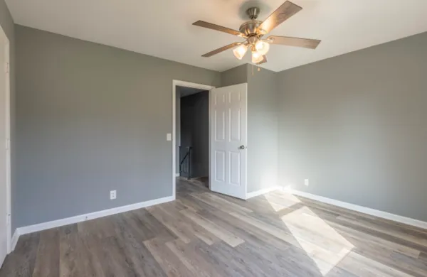 a view of a big room with wooden floor and a chandelier fan