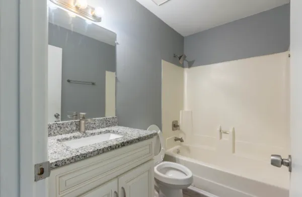 a bathroom with a granite countertop sink toilet and shower