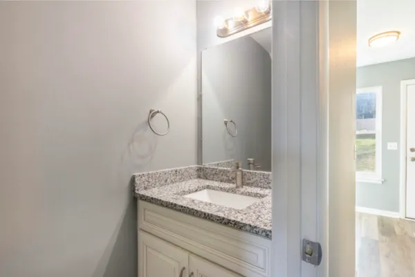 a bathroom with a granite countertop sink and a mirror