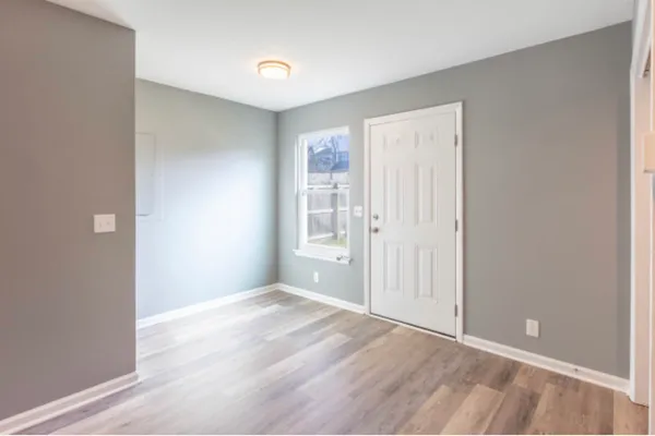 a view of an empty room with wooden floor