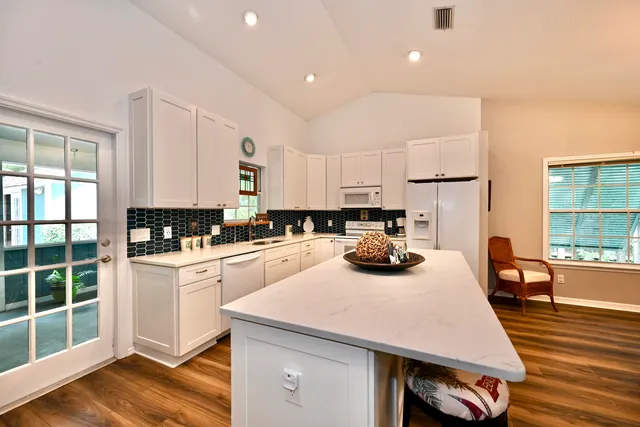 a kitchen with a sink a stove and chairs