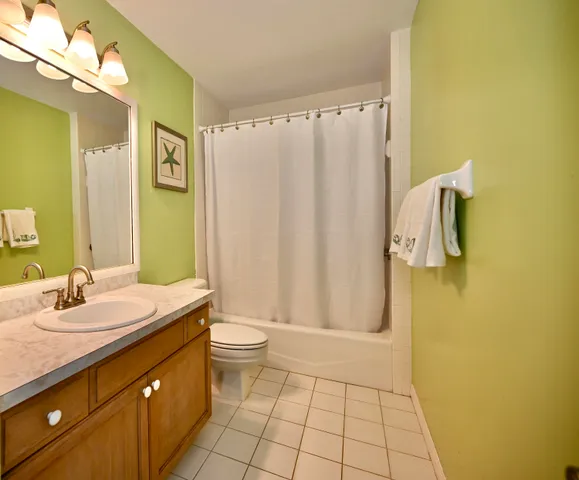 a bedroom with a bed a flat screen tv and a chandelier