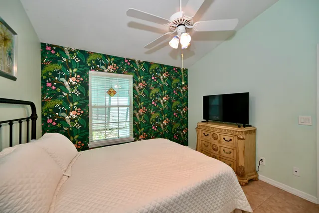 a bedroom with a large bed and a chandelier