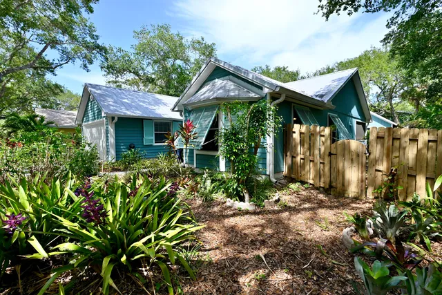 a view of a house with a tree in front of it