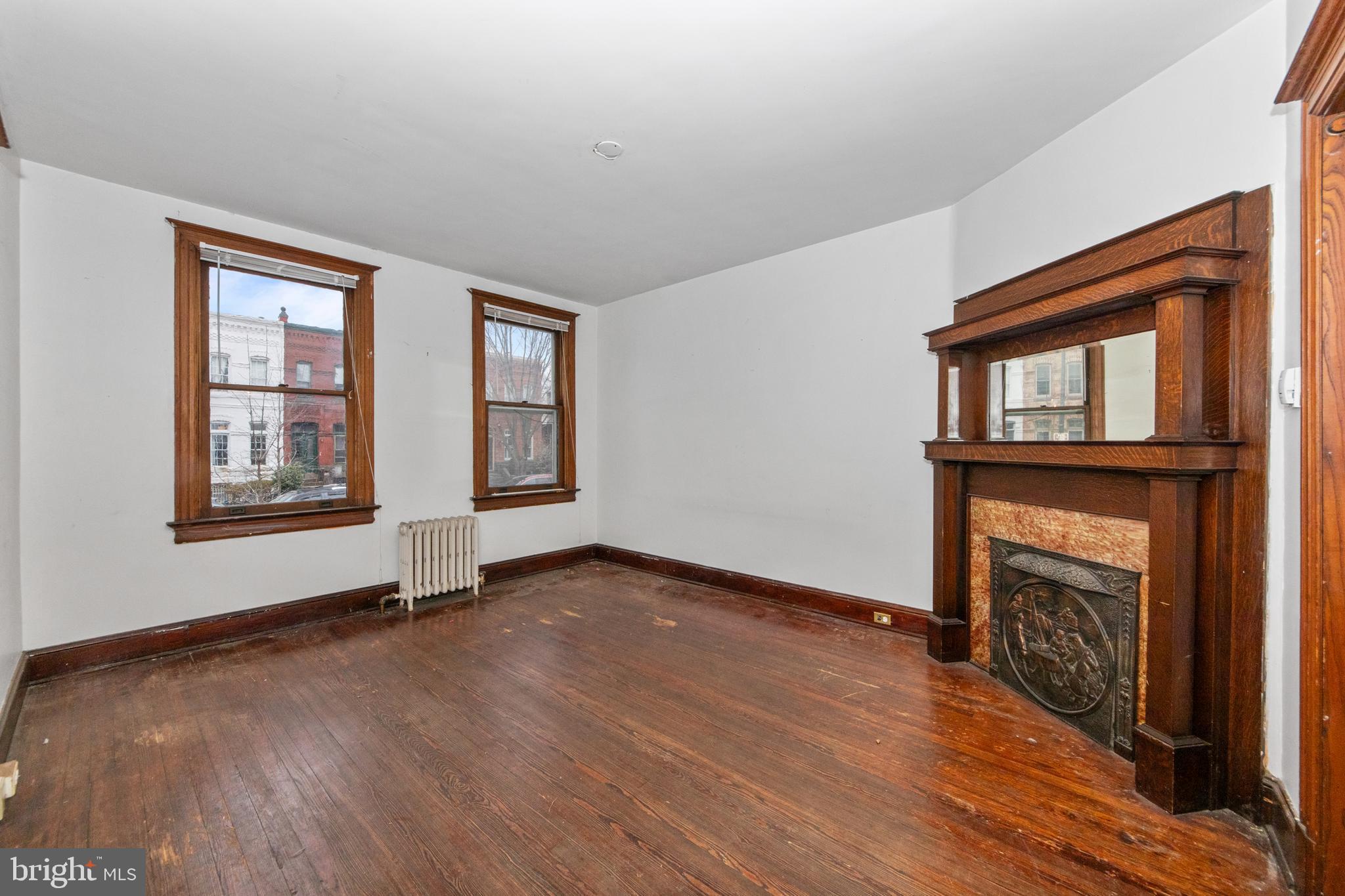 1014 Independence Avenue Southeast Washington, DC 20003 - Photo 11 of 51 an empty room with wooden floor fireplace and windows