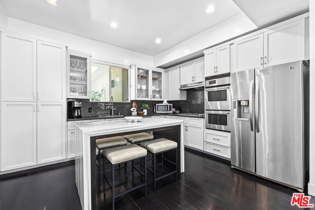 32 Galleon Street Marina del Rey, CA 90292 - Photo 8 of 24 a kitchen with white cabinets and stainless steel appliances