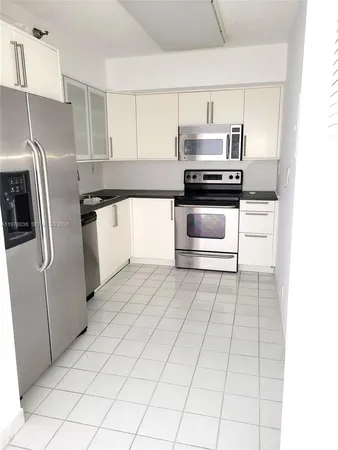 a kitchen with stainless steel appliances granite countertop a refrigerator and a stove