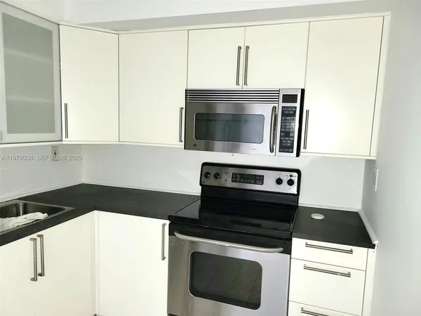 a kitchen with a stove microwave and sink