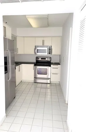 a kitchen with a stove top oven and cabinets