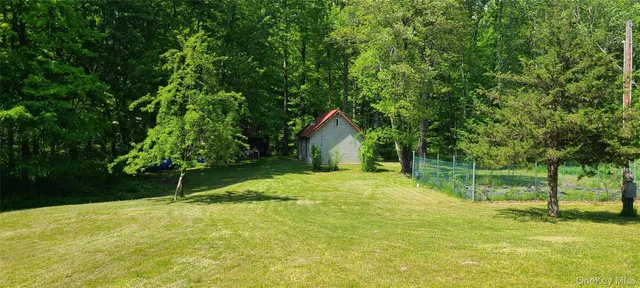 a backyard of a house with plants and large trees