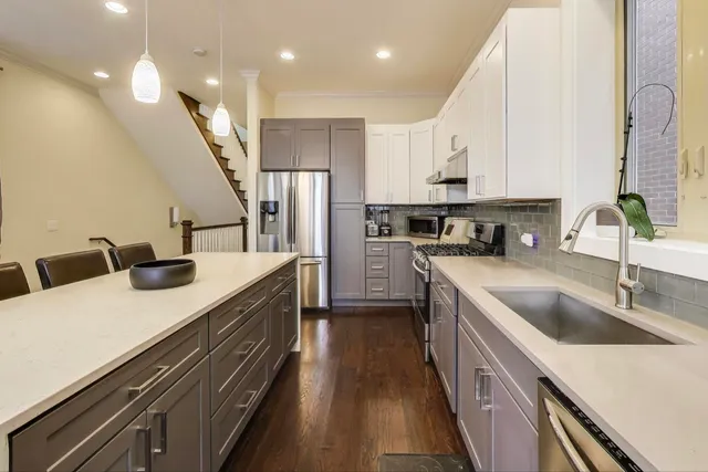 a kitchen with kitchen island a sink appliances and cabinets