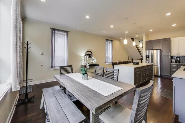 a kitchen with a table chairs refrigerator and microwave