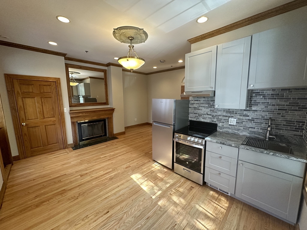 a kitchen with granite countertop a stove top oven and cabinets