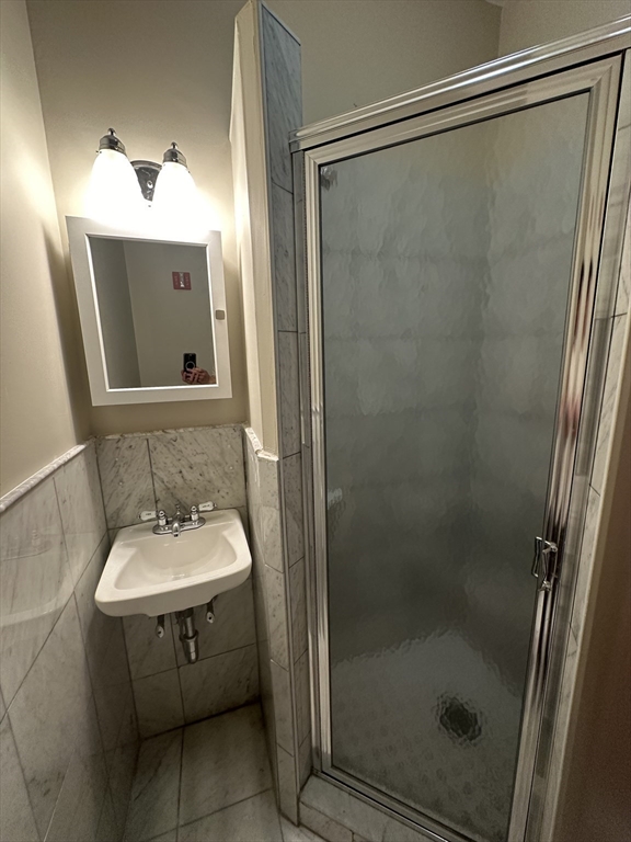 57 Gainsborough Street, Unit 2 Boston, MA 02115 - Photo 6 of 8 a bathroom with a sink a mirror and a shower