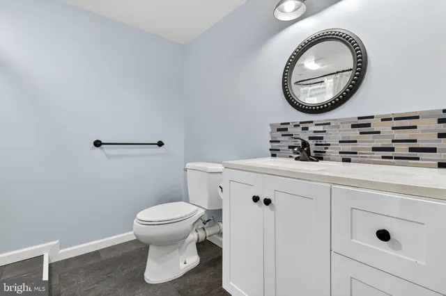 a bathroom with a toilet a sink and a mirror