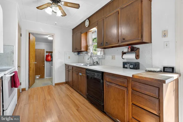 a kitchen with stainless steel appliances granite countertop a sink dishwasher and a microwave oven with wooden floor