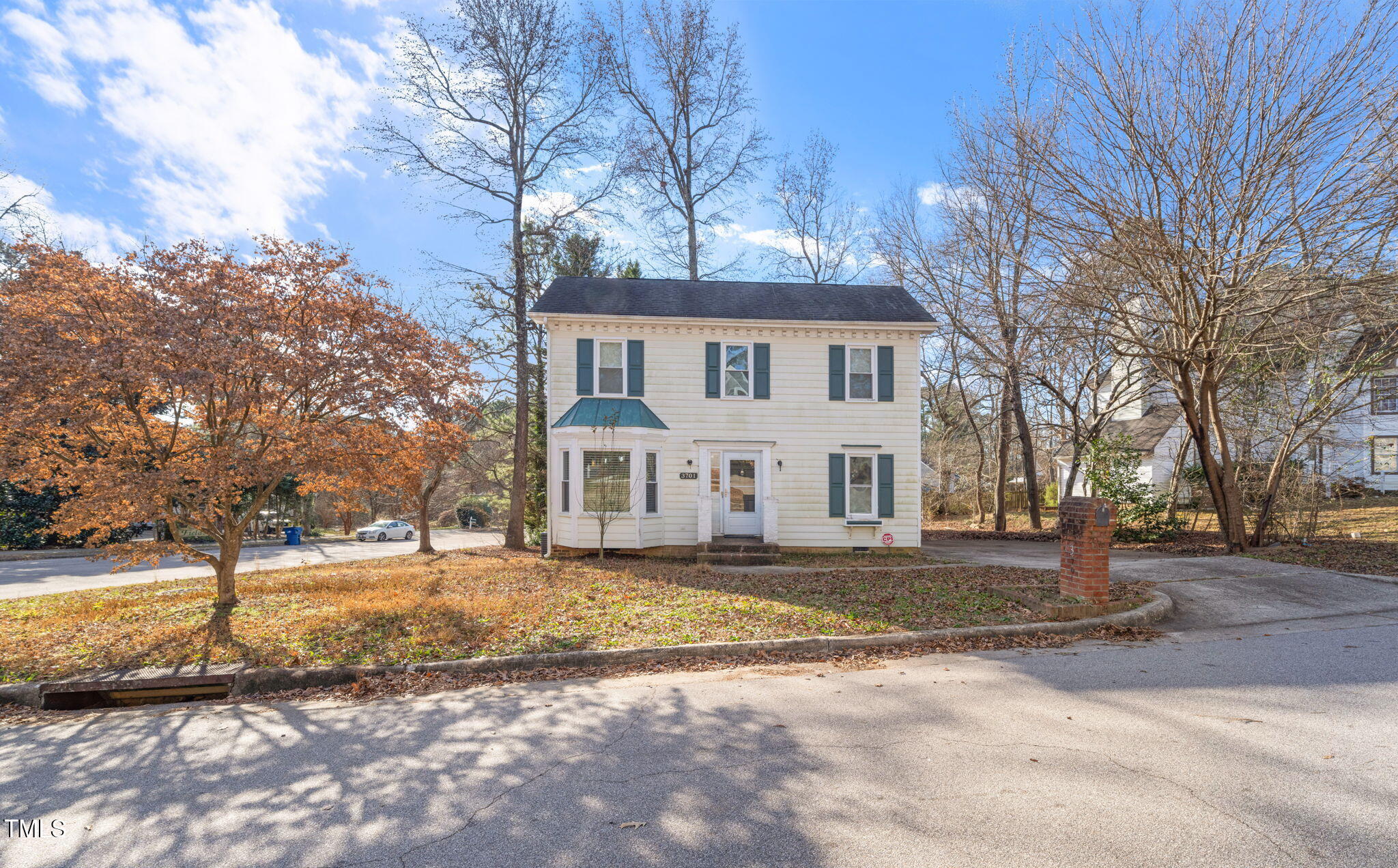 a white house that has a tree in front of it