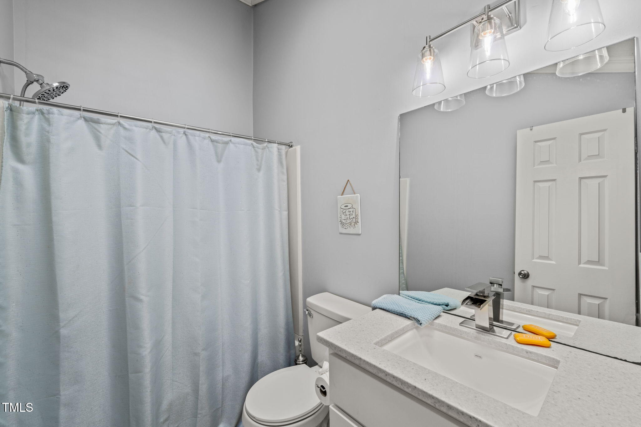 3701 East Jameson Road Raleigh, NC 27604 - Photo 18 of 26 a bathroom with a sink a toilet and shower curtain