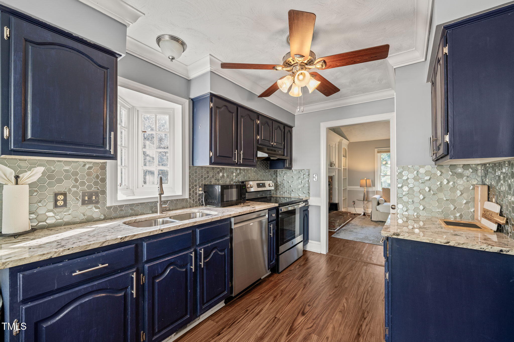 3701 East Jameson Road Raleigh, NC 27604 - Photo 7 of 26 a kitchen with a sink dishwasher a stove and a microwave oven with wooden floor