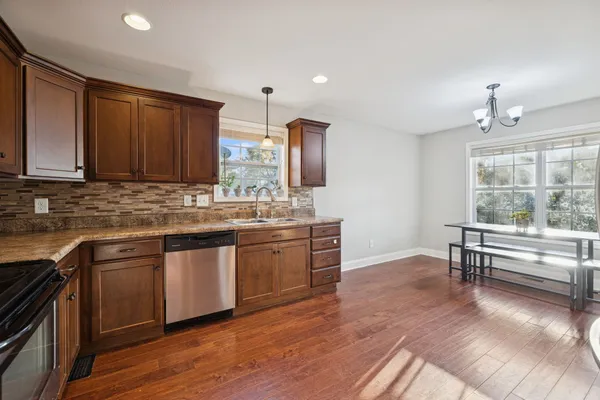 a kitchen with stainless steel appliances granite countertop a stove a sink and a refrigerator