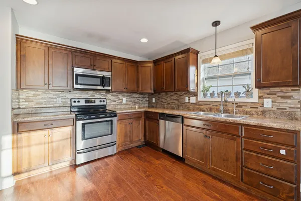 a kitchen with kitchen island granite countertop a sink cabinets and stainless steel appliances
