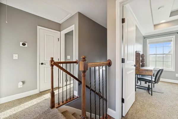 a view of a hallway with wooden floor and stairs