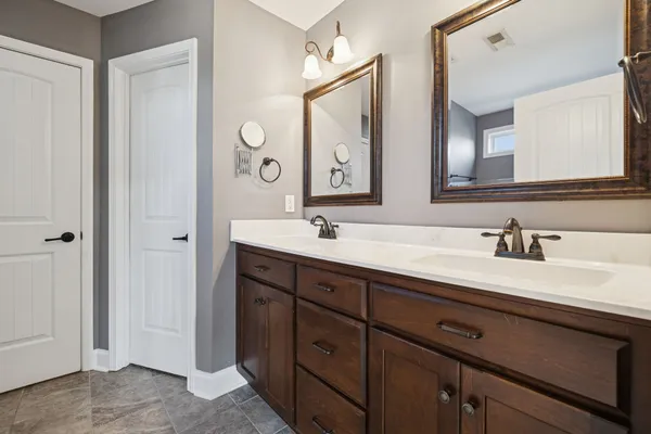 a bathroom with a double vanity sink and a mirror