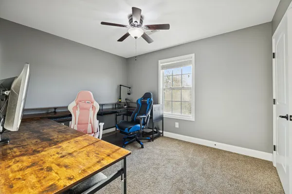 a view of a workspace with furniture and a window