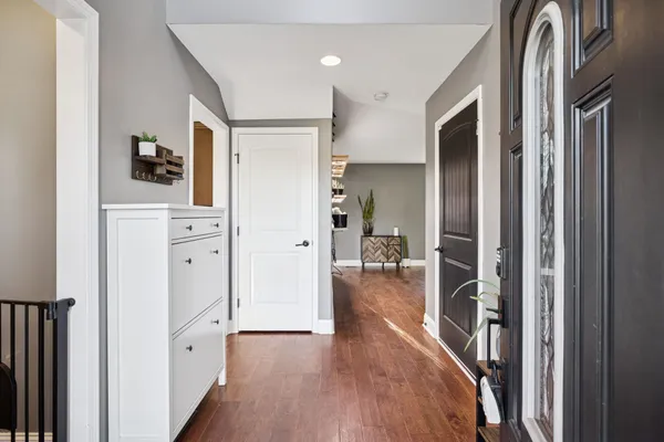 a hallway with wooden floor closet and bathroom