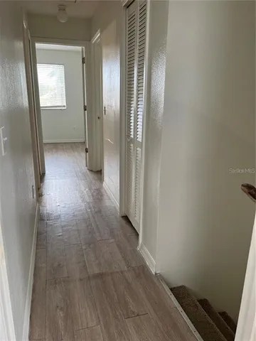 a view of a room with wooden floor and a staircase