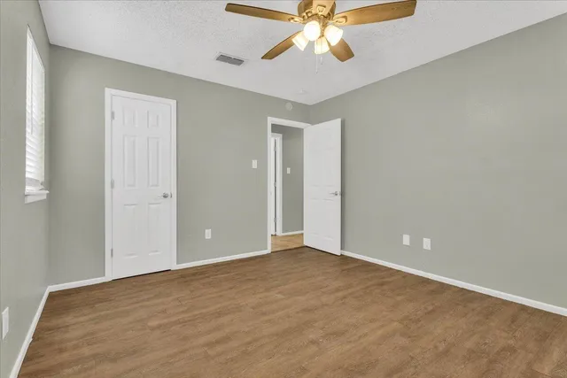 an empty room and chandelier fan