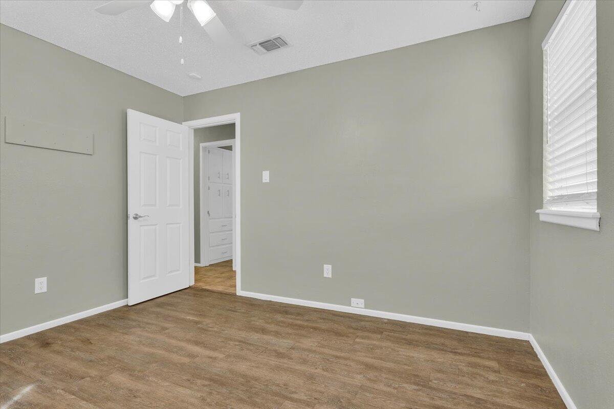 4802 54th Street Lubbock, TX 79414 - Photo 18 of 27 an empty room with wooden floor and windows