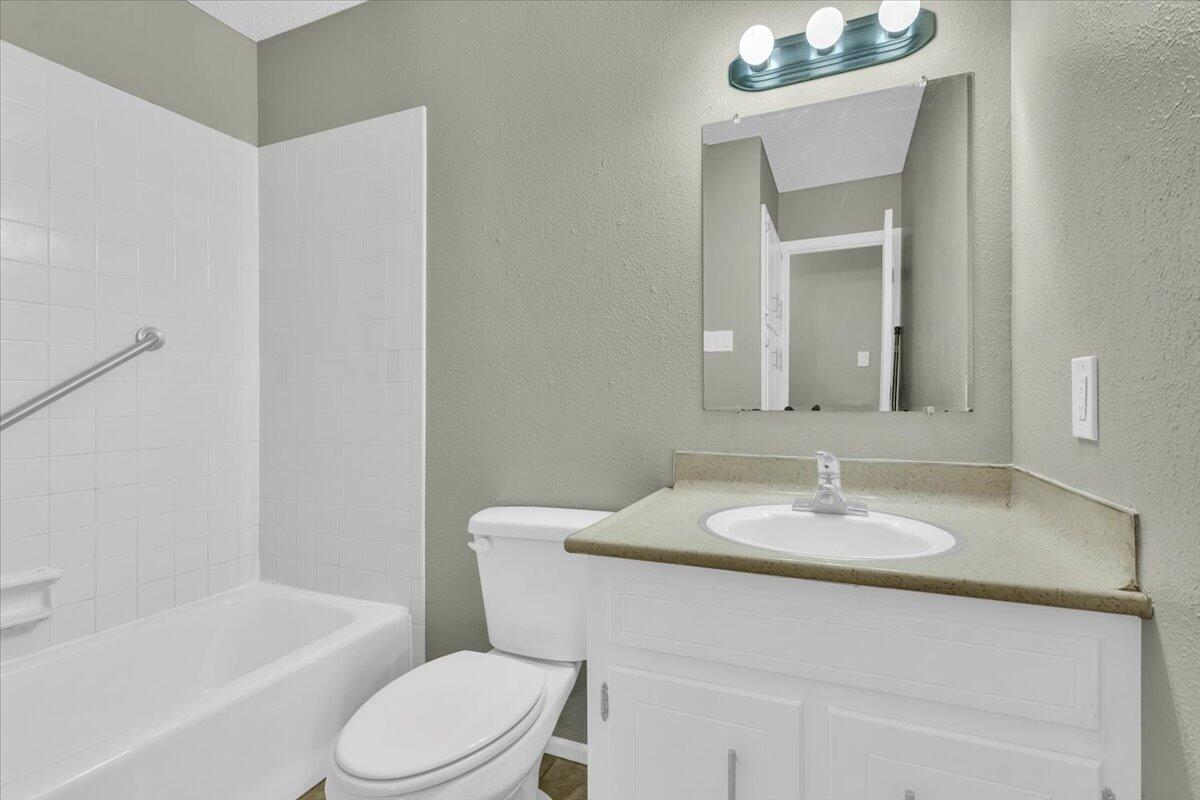 4802 54th Street Lubbock, TX 79414 - Photo 19 of 27 a bathroom with a sink toilet a mirror and shower