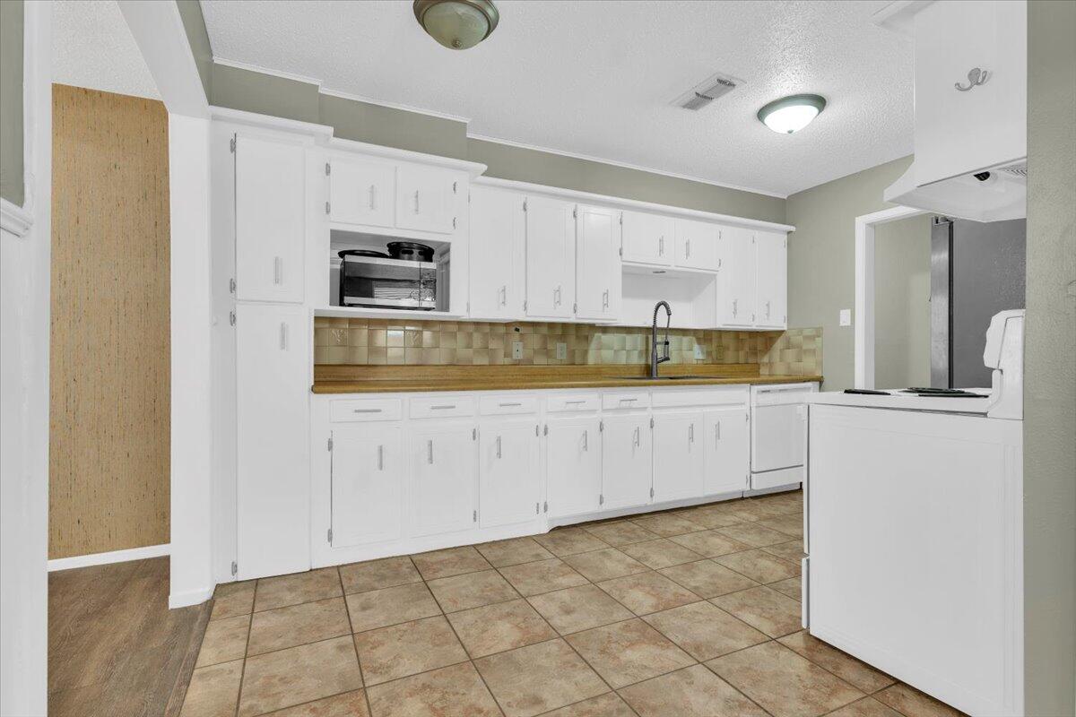 4802 54th Street Lubbock, TX 79414 - Photo 9 of 27 a kitchen with granite countertop a stove a sink and a refrigerator