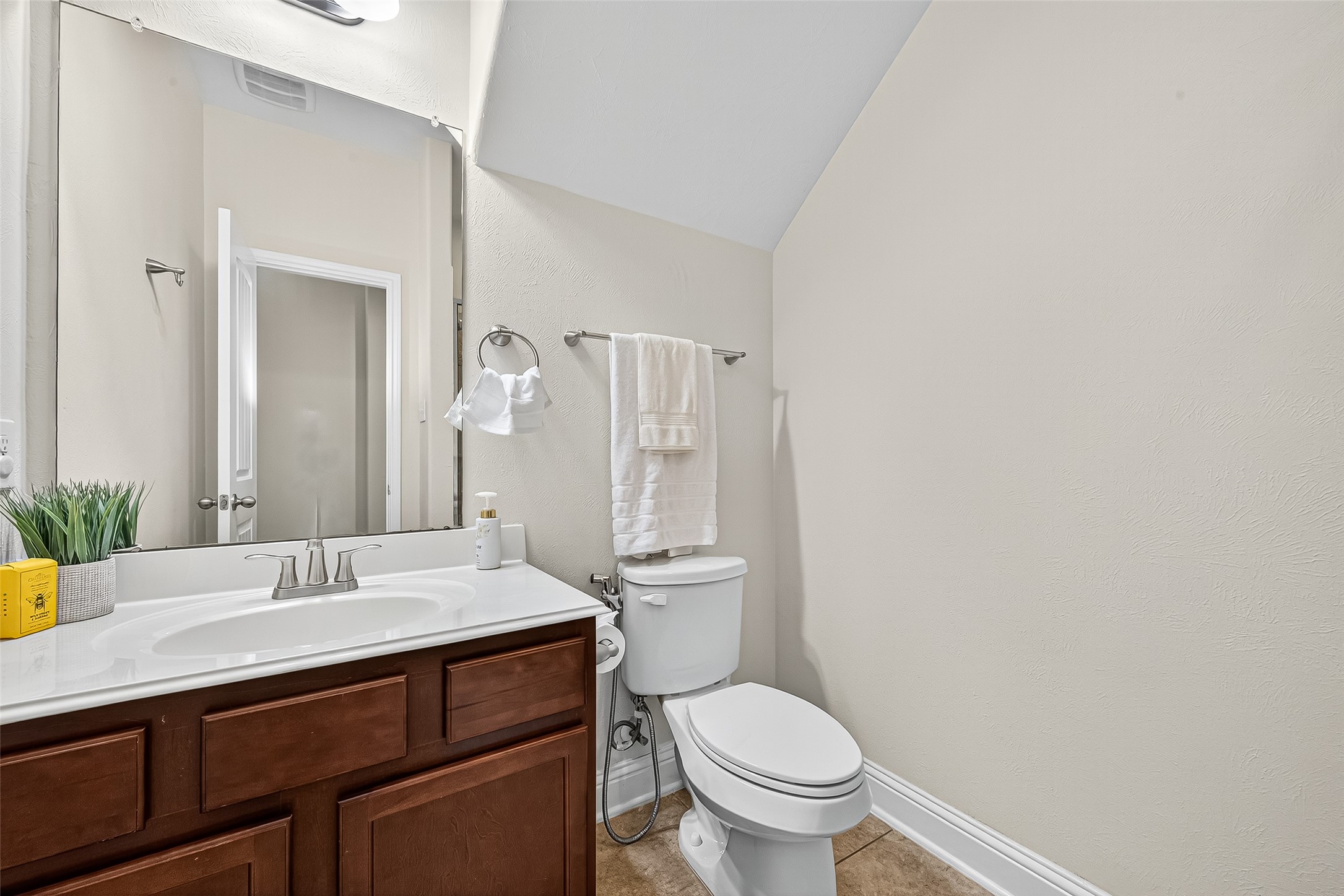 8107 Lockridge Terrace Lane Cypress, TX 77433 - Photo 26 of 50 This full bathroom, conveniently located near the downstairs bedroom, features a sleek vanity with rich cabinetry, modern lighting, and a clean, neutral palette. Ideal for guests or multi-generational living, it offers privacy and comfort with easy accessibility.