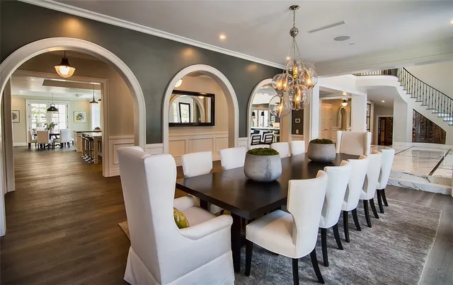 a living room with lots of furniture stairs and a large window