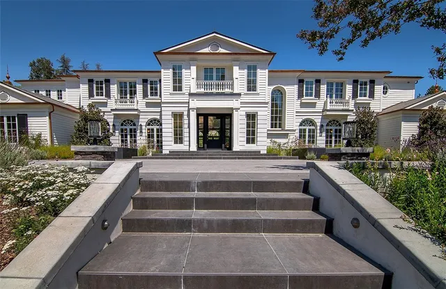 a front view of a house with yard swimming pool and outdoor seating