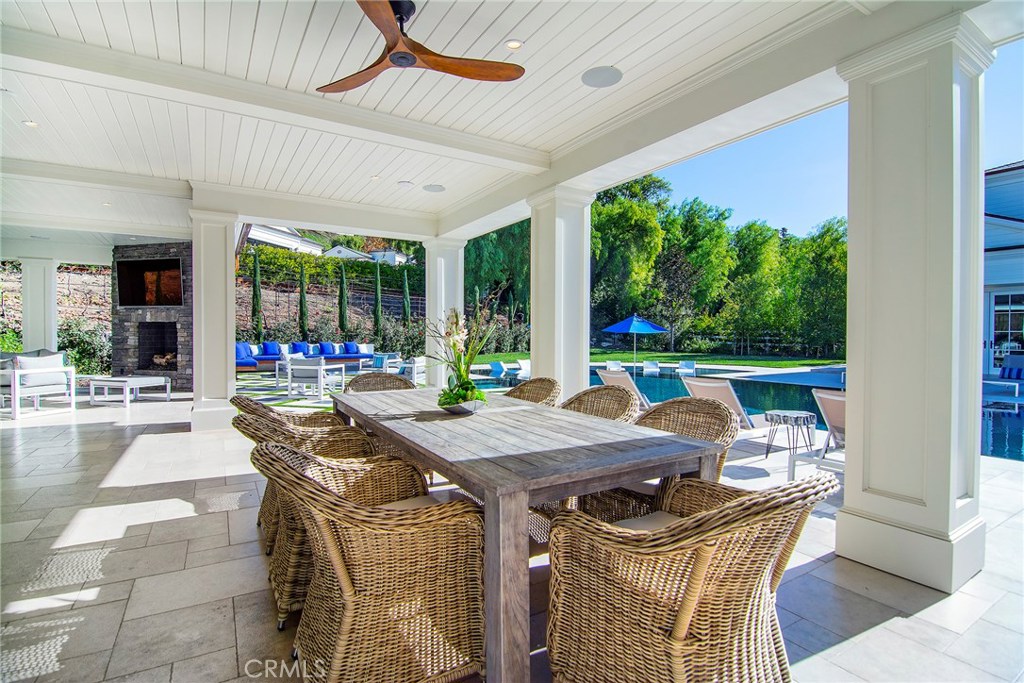 5546 Jed Smith Road Hidden Hills, CA 91302 - Photo 45 of 73 a view of a patio with a table chairs and a floor to ceiling window