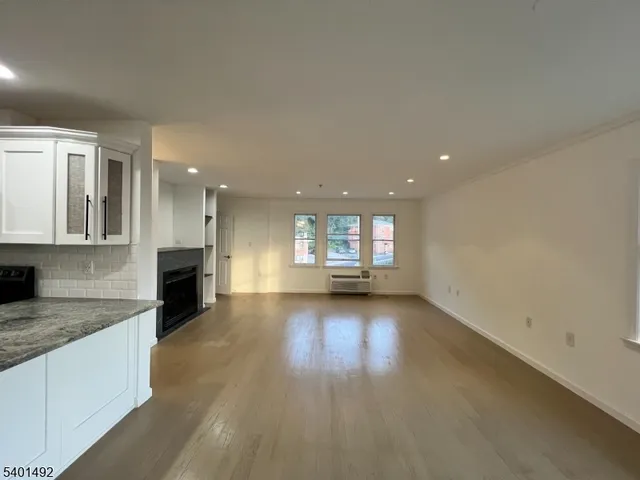an empty room with windows & fireplace