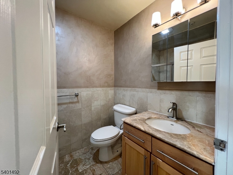 614 Fairview Avenue, Unit E Fairview, NJ 07022 - Photo 8 of 14 a bathroom with a granite countertop sink toilet and mirror