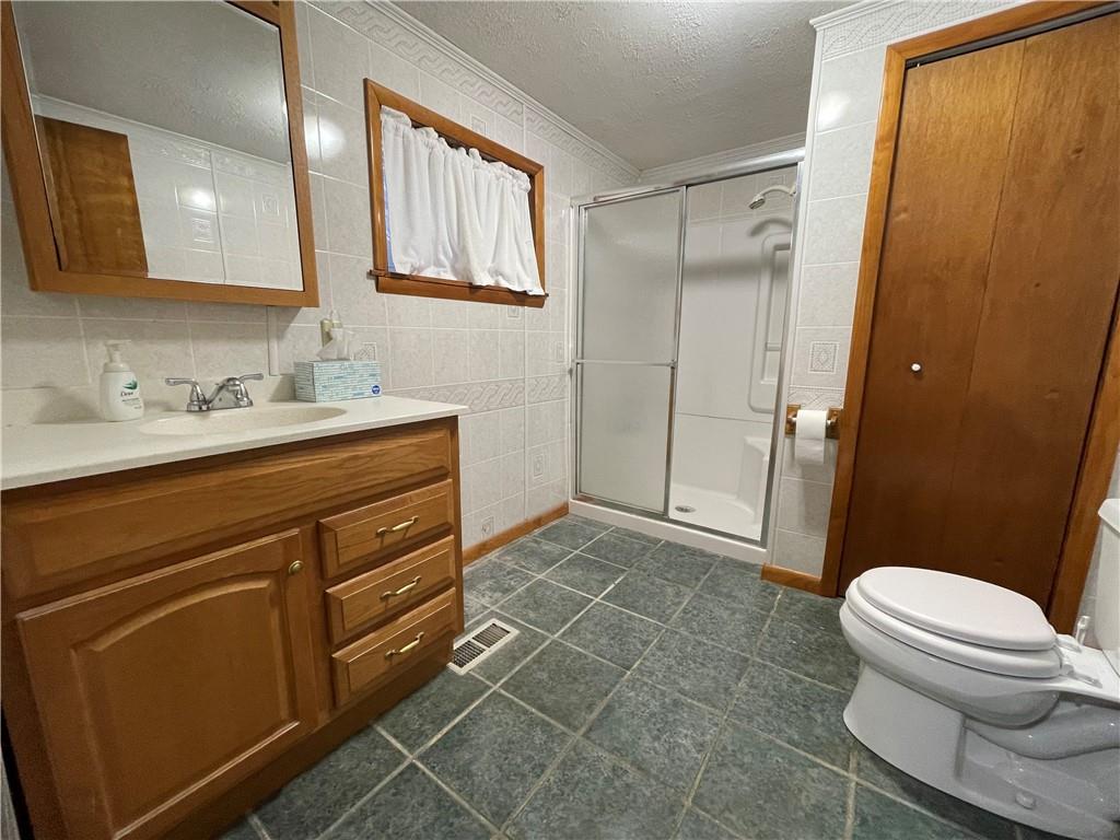 4551 Hollow Road New Castle, PA 16101 - Photo 12 of 21 a bathroom with a sink a toilet a mirror and shower