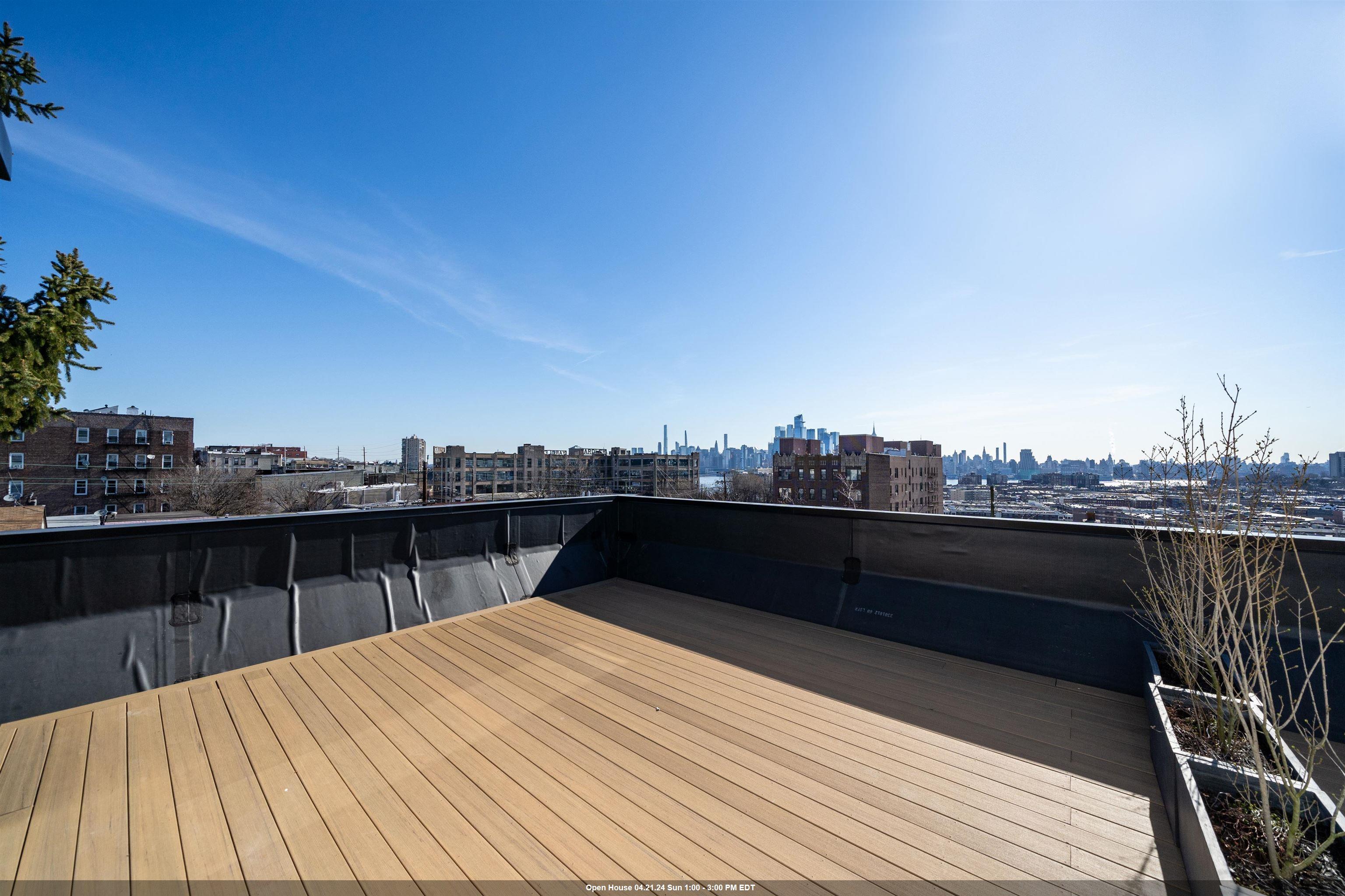 a view of a roof deck with two couches and sky view