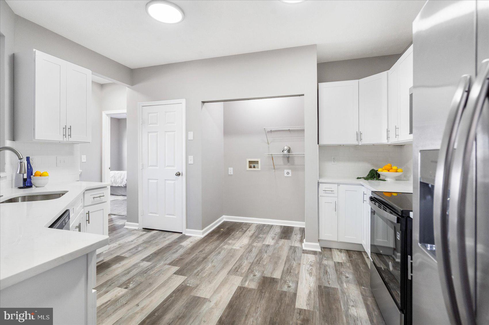 5386 Glenthorne Court, Unit 5386 Baltimore, MD 21237 - Photo 16 of 36 a kitchen with white cabinets and stainless steel appliances