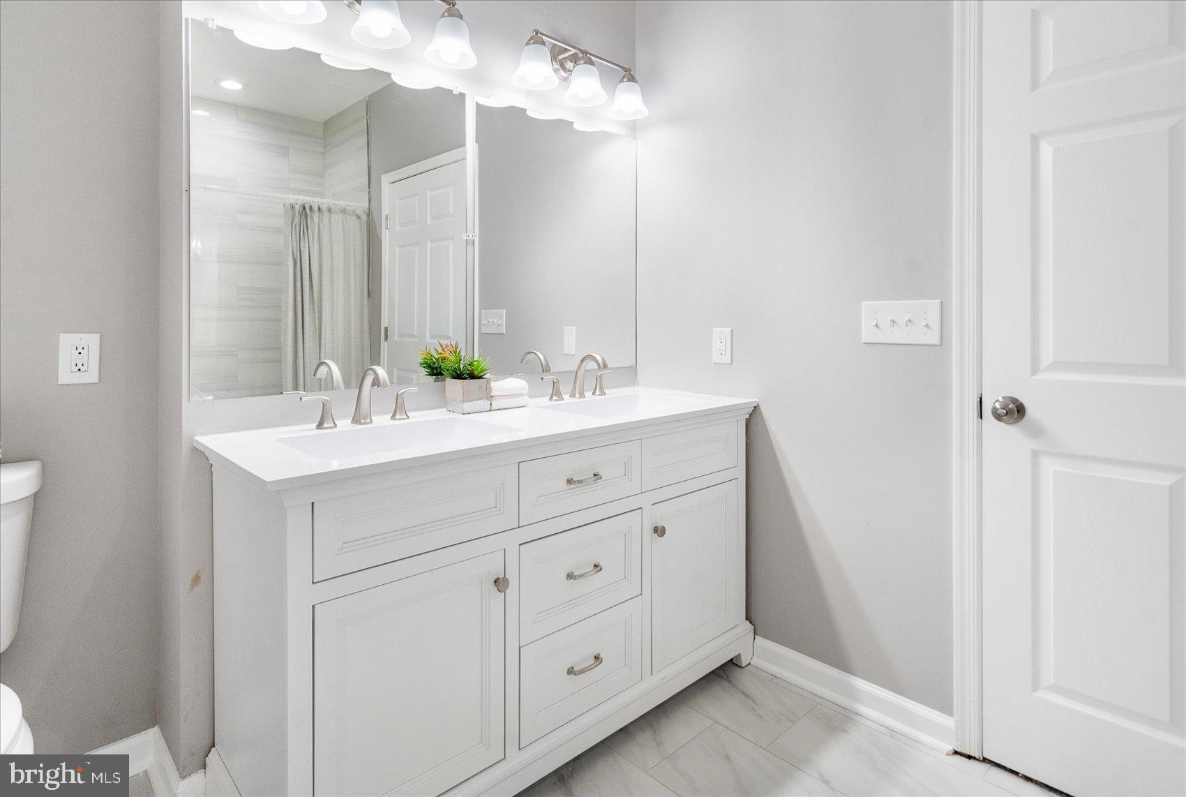 5386 Glenthorne Court, Unit 5386 Baltimore, MD 21237 - Photo 32 of 36 a bathroom with a double vanity sink mirror and
