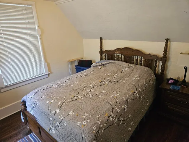 a bed sitting in a bedroom next to a window