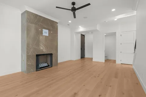 a view of empty room with a fireplace and wooden floor