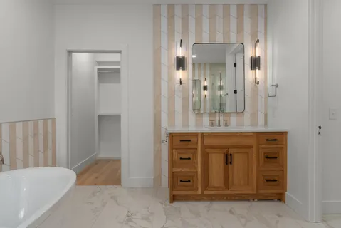 an empty room with wooden floor chandelier and windows